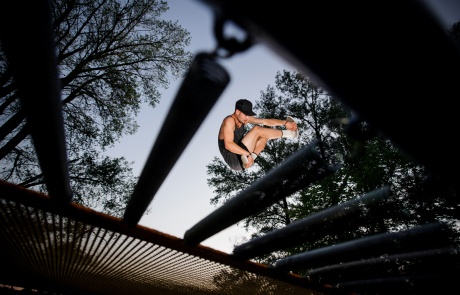Bottom view of a young man trampolining in a park